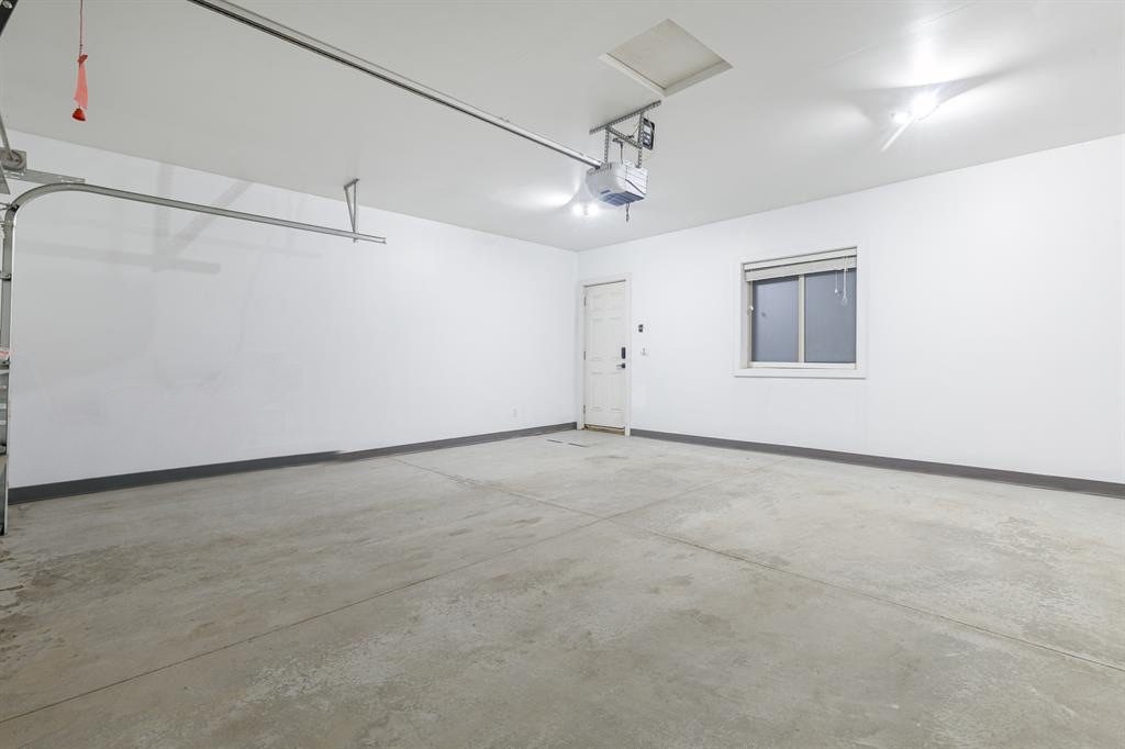 Clean, bright two-car garage interior with an automatic opener