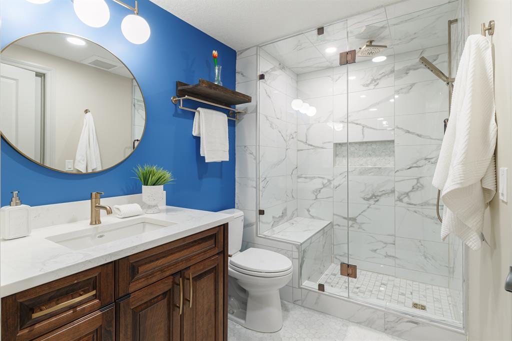 Bathroom with glass shower, bench and marble-look tile