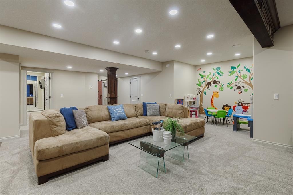 Large carpeted recreation room with a jungle mural in the play corner