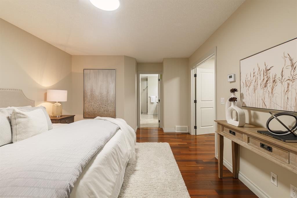 Bright primary bedroom with light furniture and a passage to the ensuite
