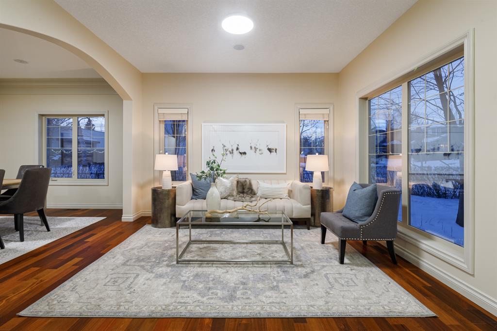 Living room with tall windows and an arched opening to the dining room